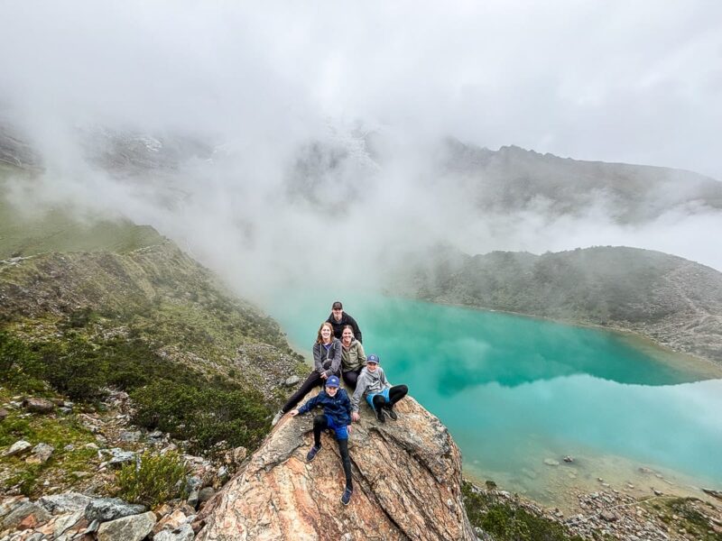 family on rock over Humantay Lake