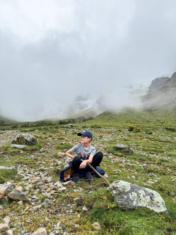 boy resting on hike to Humantay Lake