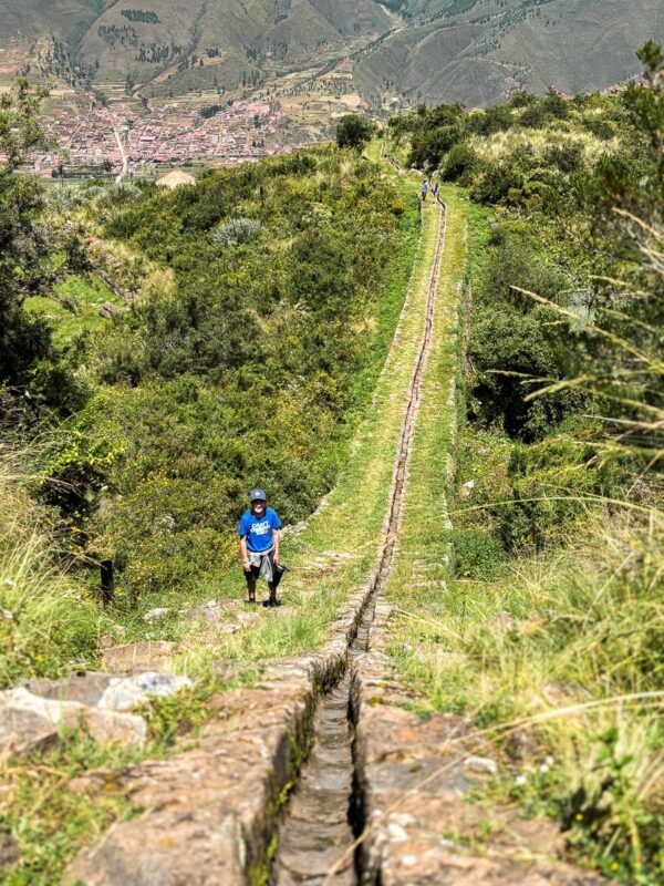 boy standing by water aquaduct by Tipon