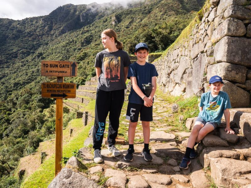 kids by Machu Picchu sign
